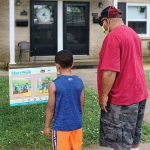 Henderson County (Ky.) Public Library’s StoryWalk participants read a page from picture book Jonathan and His Mommy last summer.