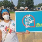 A protester at the Save Niles Library rally in July. Organizers met at a local park, then marched to the library for a public hearing on proposed budget cuts.