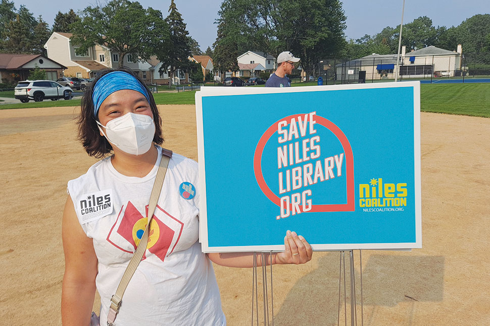 A protester at the Save Niles Library rally in July. Organizers met at a local park, then marched to the library for a public hearing on proposed budget cuts.