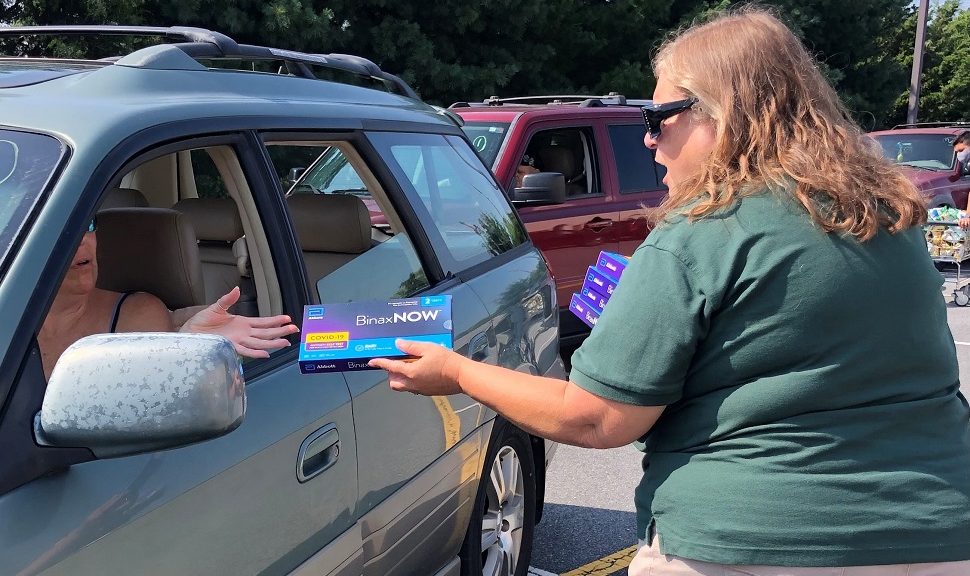 Kathy McFadden (right), a staffer at Sussex County (Del.) Libraries, hands out rapid, at-home COVID-19 testing kits during a drive-through distribution event at Seaford (Del.) District Library in August 2021. Photo: Delaware Division of Libraries