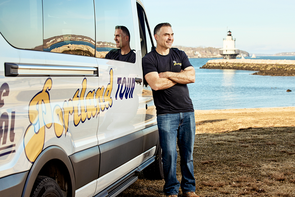 Derek Meader, reference librarian at Southern Maine Community College in South Portland, stands in front of Spring Point Ledge Lighthouse, a 54-foot sparkplug-like structure adjacent to campus. Meader is the owner and operator of The Real Portland Tour, a sightseeing experience that stops at three Maine lighthouses. Photo taken by Michael D. Wilson.