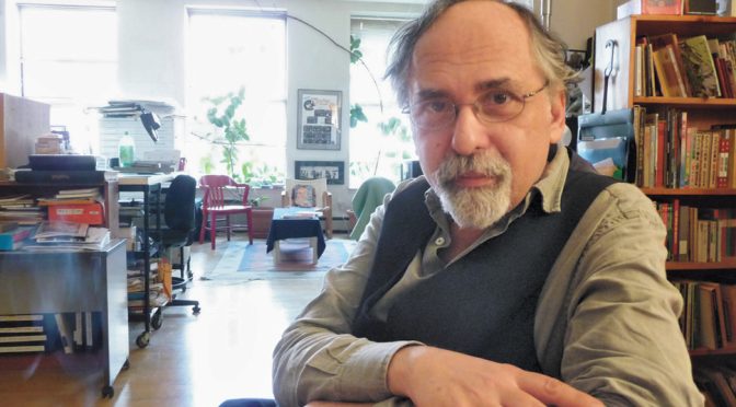 Photo of author Art Spiegelman sitting with arms crossed on table