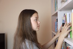 Girl looking at books on a shelf