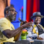 Seated at left, author and MacArthur Fellow Reginald Dwayne Betts speaks into a microphone. Seated to the right is author and professor Randall Horton. Both are presenters at "Defending the Fifth Freedom: Protecting the Right to Read for Incarcerated Individuals," a June 25 session at the American Library Association's 2022 Annual Conference and Exhibition in Washington, D.C. Photo by EPNAC.