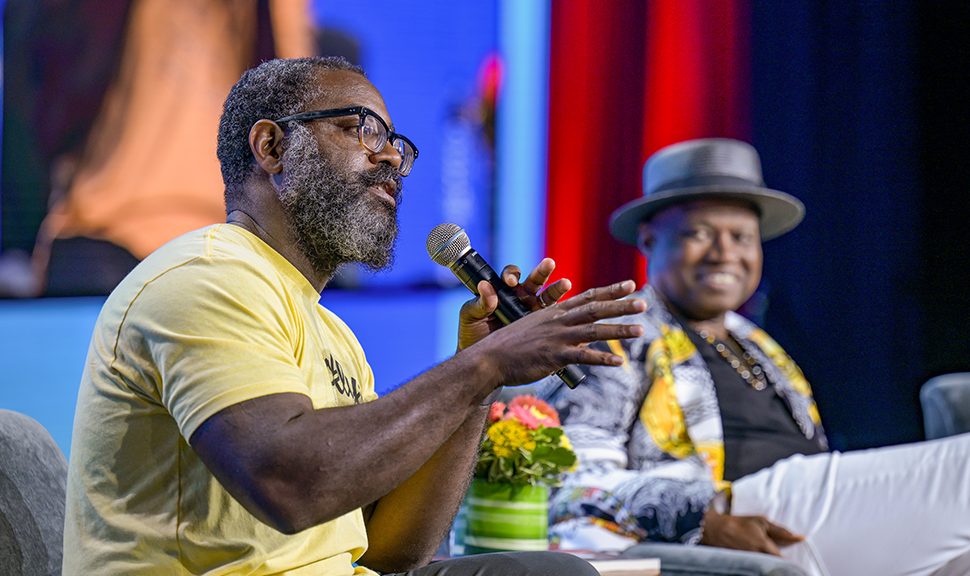 Seated at left, author and MacArthur Fellow Reginald Dwayne Betts speaks into a microphone. Seated to the right is author and professor Randall Horton. Both are presenters at "Defending the Fifth Freedom: Protecting the Right to Read for Incarcerated Individuals," a June 25 session at the American Library Association's 2022 Annual Conference and Exhibition in Washington, D.C. Photo by EPNAC.
