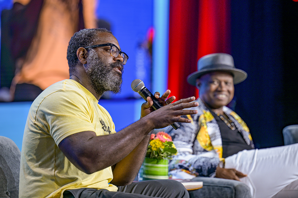 Seated at left, author and MacArthur Fellow Reginald Dwayne Betts speaks into a microphone. Seated to the right is author and professor Randall Horton. Both are presenters at "Defending the Fifth Freedom: Protecting the Right to Read for Incarcerated Individuals," a June 25 session at the American Library Association's 2022 Annual Conference and Exhibition in Washington, D.C. Photo by EPNAC.