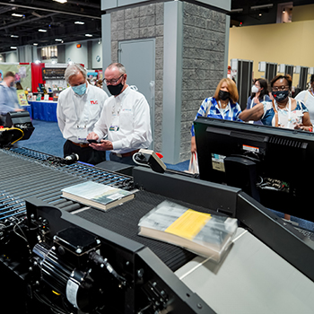 A demonstration of equipment for sorting books at the Tech Logic booth.