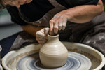 Close-up of hands throwing a pot on a pottery wheel