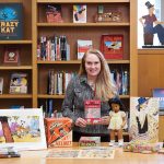 Head curator Jenny Robb poses with collection items from the Billy Ireland Cartoon Library and Museum