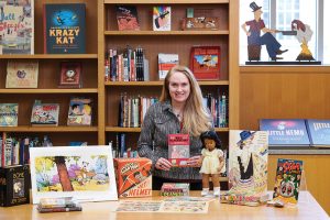 Head curator Jenny Robb poses with collection items from the Billy Ireland Cartoon Library and Museum