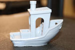 A 3D-printed benchy, in the shape of a small boat with elaborate holes, used to identify issues with 3D printers