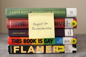 Stack of five library books with a post-it note that reads "Request for Reconsideration"