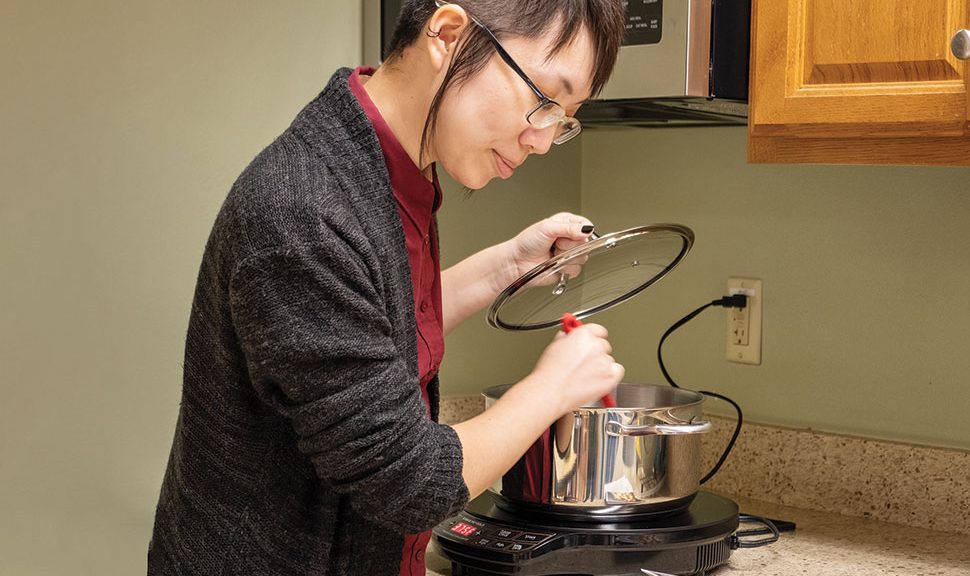 Aydin Kwan, adult services librarian at Sunnyvale Public Library uses an induction cooktop available for loan.