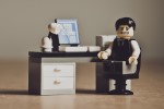 Lego figure of a frustrated man at a desk