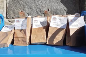 Image shows a row of paper bags filled with Maynard (Mass.) Public Library's February spice of the month, fenugreek.