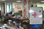 Interior of Portland State Library showing messages painted on the wall and aid station set up by protestors