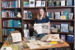 Kelley Woolley poses with items from the San Diego Zoo Wildlife Alliance library collection