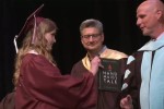 Annabelle Jenkins hands West Ada School District superintendent Derek Bub a copy of The Handmaid's Tale at the high school graduation ceremony.
