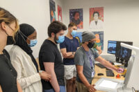 Ted Quiballo, instructional technologies librarian at Northwestern University in Evanston, Illinois, shows interns for World Relief Chicagoland’s youth summer program how to use a 3D scanner.