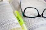 Glasses and a highlighter sitting in a book