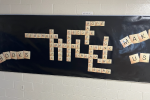 Bulletin Board display with scrabble tiles spelling out Books Make Us and a variety of interlocking words about literacy