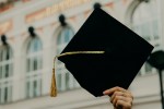 Hand holding up a graduation cap