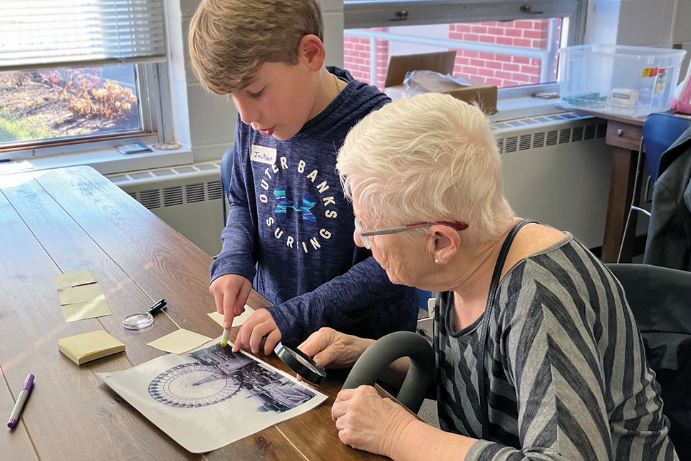 An older woman and a child look at a photo of a Ferris wheel.