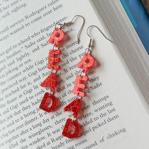 Red earrings spelling "read" vertically