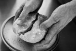 Close-up of hands splitting a piece of bread