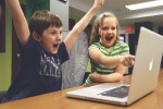 Children celebrating at a computer