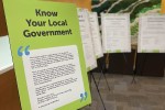 A series of posters with text, set up on easels. The first poster is titled "Know Your Local Government."