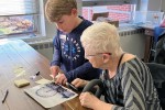 An older woman and a child look at a photo of a Ferris wheel.