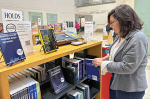 Doreen Horstin, manager of San Fran­cisco Public Library’s Park branch, adds a book to the Read to Recovery shelves, which provide free addiction recovery materials to patrons.