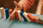 Domino rally being blocked by a hand