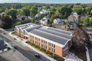 A red brick building with a curved roof completely covered in solar panels