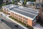 A red brick building with a curved roof completely covered in solar panels