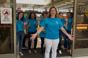 Altadena Library District staffers wearing matching t-shirts gather to greet patrons at the Main Library's entrance.