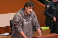 Chris Kluwe speaking into a microphone atop a podium