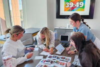 Four students work through an activity with a digital countdown clock in the background.