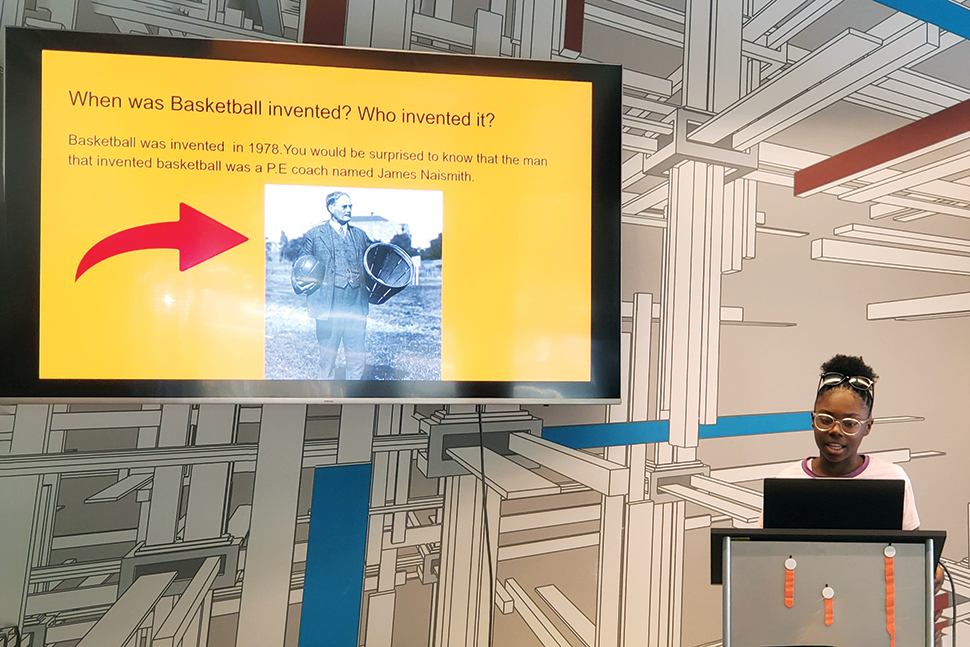 A young presenter shares slides about the history of basketball at Vestavia Hills (Ala.) Library’s summer 2024 PowerPoint Party.