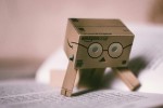 Cardboard robot reading a book