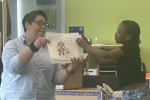 Juana Medina with a student presenting a self-portrait