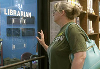 A woman enters a librarian's office in a screencap from The Librarians