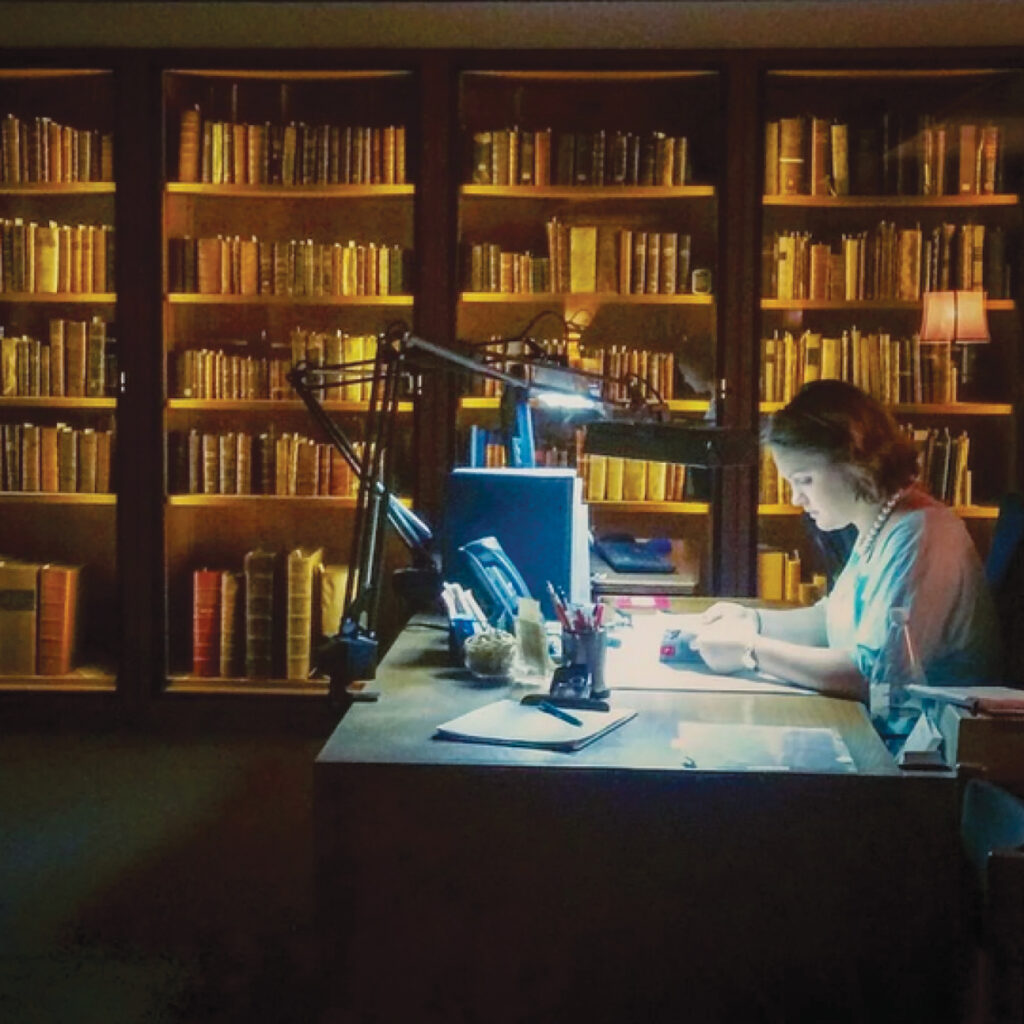 Woman reading a book at a desk at the library