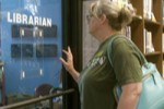 Screencap from The Librarians featuring a woman entering a door with Librarian written on it.