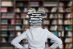 Woman in a library with a stack of books for a head