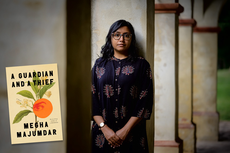 Author Megha Majumdar standing by pillars of a building