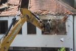 Excavator breaking a wall