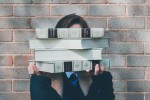 Woman holding books obscuring her face
