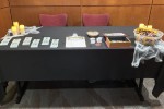 Check in table with a black tablecloth and spiderweb decorations.